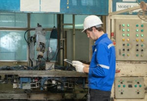 manufacturing worker in blue jacket with tablet